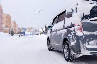 Kapalı gri minibüs. Kirli araba, şehir merkezine karla kaplanmış.