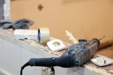 Portre profesyonel inşaat tozlu matkap, onarım, inşaat, yeniden yapılanma, tuğla, merdiven arka plan üzerinde zımba. Kavram yükleme ve ofis binası kapı ve pencerelerin sökülmesi