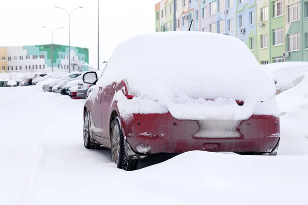 Primer plano de pequeño coche sucio rojo cubierto de soportes de nieve contra — Foto de Stock