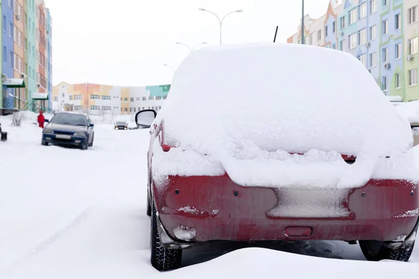 Primer plano de pequeño coche sucio rojo cubierto de soportes de nieve contra — Foto de Stock