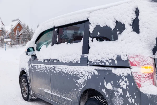 Primer plano gris minibús coche sucio cubierto de nieve en backgro de la ciudad — Foto de Stock