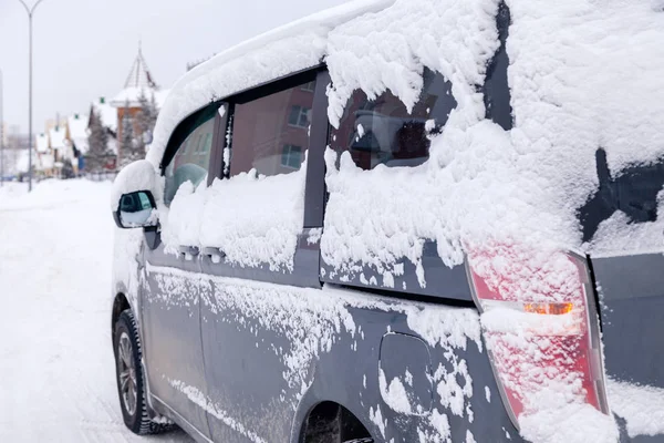Крупный план серый микроавтобус грязный автомобиль, покрытый снегом на городской backgro — стоковое фото