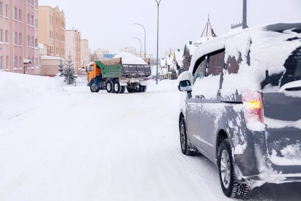 Zbliżenie szary minibus brudne samochód pokryte śnieg na miasto backgro — Zdjęcie stockowe