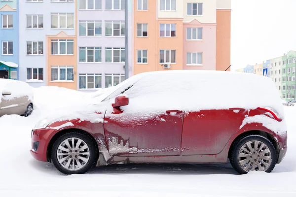 Крупный план маленького красного грязного автомобиля, покрытого снегом — стоковое фото