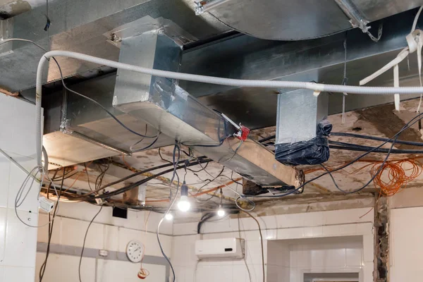 Installation and repair of frame, ventilation system, electric cable, lamp bulb before assembling stretch or suspended ceiling. Concept of reconstruction in an office building