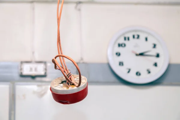 Closeup clock and installation and repair of electric cable, smoke detector, fire alarm system before installing stretch or suspended ceiling. Concept testing fire extinguishing systems, protection