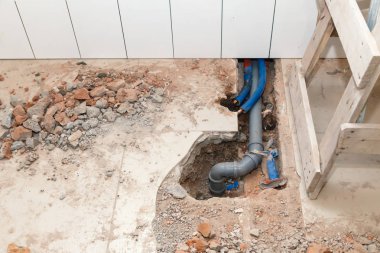 Tuğla yerde kırık taşlarla delik plastik Polipropilen gri kanalizasyon boruları tamir. Boru yerine, su kaçağı, su temini, transferini kavramı lavabolar