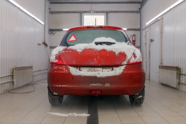 Rusya Kemerovo 2019-01-05 arka of Suzuki Swift parlak kırmızı küçük araba Profesyonel oto yıkama karda kir içinde. Dış, elektrikli süpürge, kimyasal deterjan ile iç için kapsamlı bakım kavramı