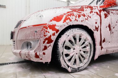 Rusya Kemerovo 2019-01-05 Suzuki Swift parlak kırmızı küçük araba beyaz köpüklü oto yıkama, oto temizlik için profesyonel kimyasal deterjan. Dış ve iç için kapsamlı bakım kavramı