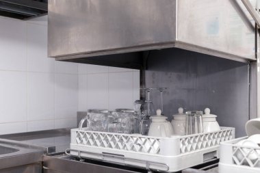 Restorandaki bulaşık makinesinde temiz aletler. Şarap bardakları, bira bardakları, seramik çaydanlıklar. Açılış, ziyafet, yemek, açık büfe için hazırlık kavramı.