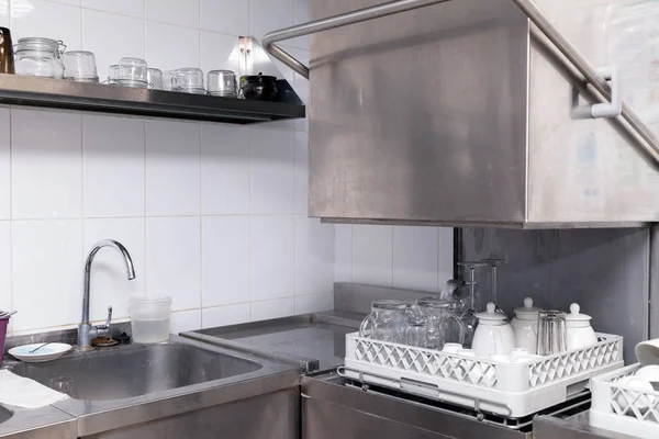 Restorandaki bulaşık makinesinde temiz aletler. Şarap bardakları, bira bardakları, seramik çaydanlıklar. Açılış, ziyafet, yemek, açık büfe için hazırlık kavramı.