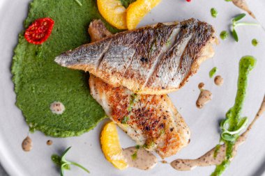 Yeşil bezelye püresi ile Closeup kızarmış levrek fileto, domates, sa