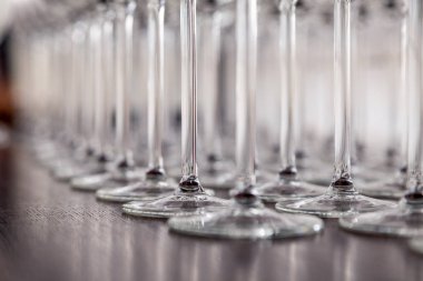 Birçok şeffaf kristal şarap kadehleri kahverengi satırda duruyor 