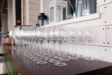 Birçok şeffaf kristal şarap kadehleri kahverengi satırda duruyor 