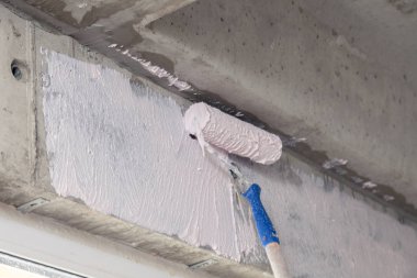 Pencerenin üstündeki duvarda boya rulosu ve astar var. Konsept