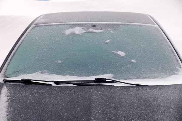 Car covered with snow stands in the parking lot of residential building in winter. oncept of bad weather, snowfall, harsh weather conditions, frost, blizzard, car engine did not start