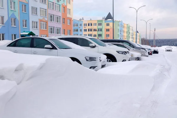 Россия Кемерово 2019-01-07 Зимой в жилом здании автостоянки покрыты снегом автостоянки. Плохая погода, снегопад, сложные погодные условия, гололед, метель, двигатель автомобиля не запущен — стоковое фото