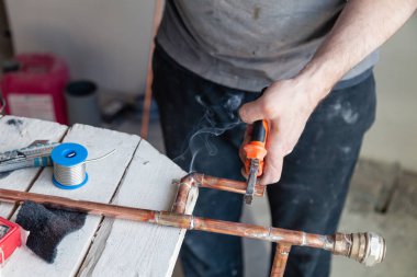 Closeup profesyonel usta tesisatçı eller lehim bakır borular