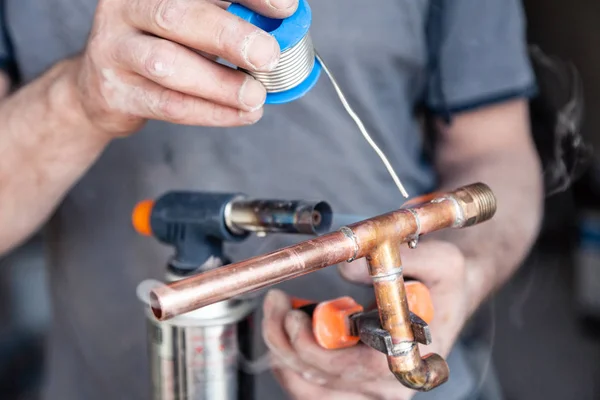 Closeup professional master plumber holding flux paste for solde — Stock Photo, Image