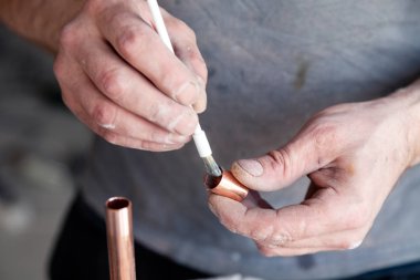  işçi tesisatçı ustası profesyonel fırça ile bakır borular temizlik. Konsept kurulumu, değişen boru hattı, lehim akısı yapıştırıcısı, profesyonel onarım, sızıntı, mola