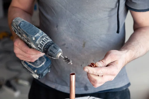 worker plumber master cleaning copper pipes with professional brush. Concept installation, changing pipeline, solder flux paste, professional repair, leakage, break