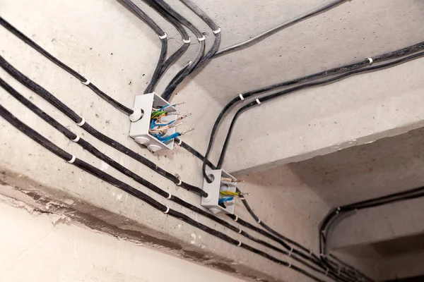 Techo tendido por cable. Cables eléctricos en la pared. Cambio de cableado. Conexión de luz plana u oficina. Bombilla de instalación profesional, toma de corriente eléctrica, cables, cables, interruptores. Aislamiento — Foto de Stock