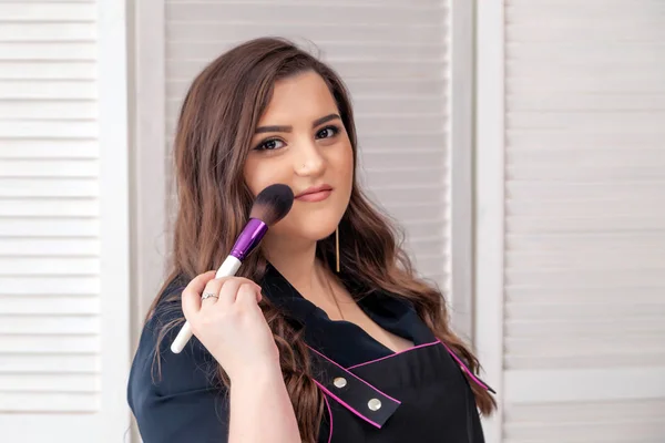 Professional makeup artist, visagiste beautiful plus size girl