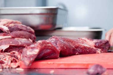 Adam kasap şef in closeup elleri çiğ fileto dilimleri kesme