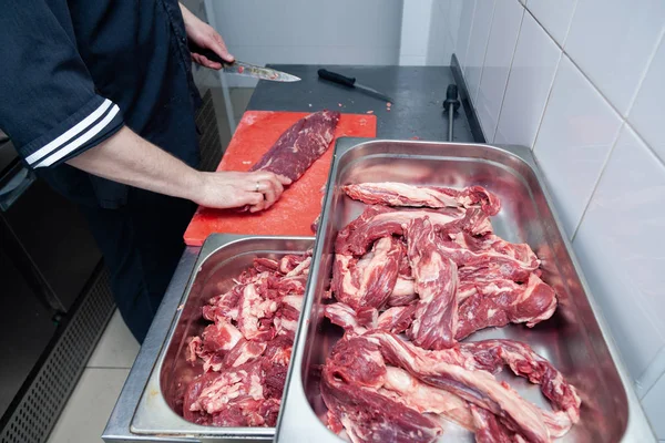 Primeros planos manos de hombre carnicero chef cortar rebanadas de filete crudo — Foto de Stock