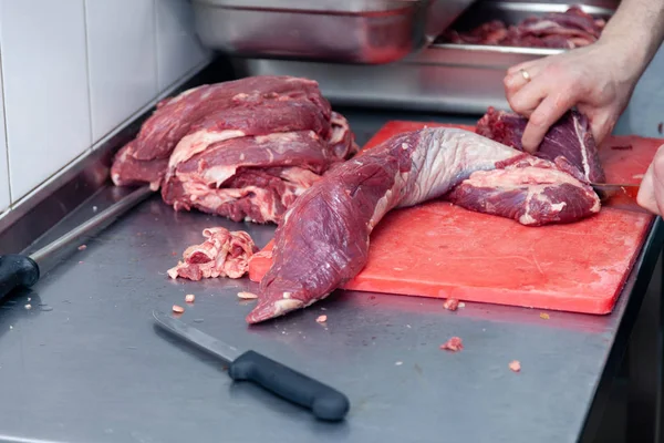 Primeros planos manos de hombre carnicero chef cortar rebanadas de filete crudo — Foto de Stock