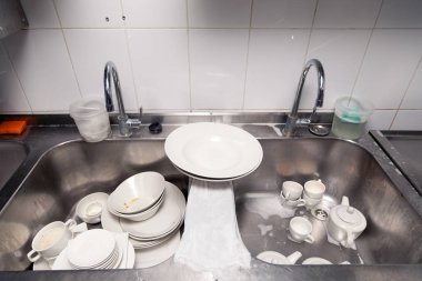 Metal kare lavabo nun altındaki kirli bulaşıkların kapatılması