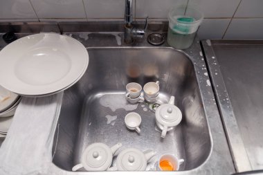 Metal kare lavabo nun altındaki kirli bulaşıkların kapatılması