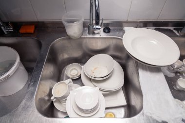 Metal kare lavabo nun altındaki kirli bulaşıkların kapatılması 