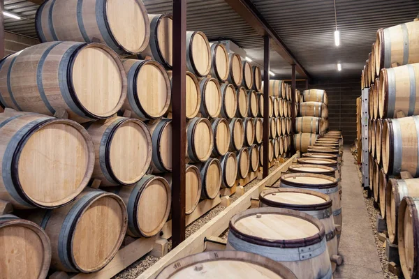 Wooden wine oak barrels stacked in straight rows in order, old c