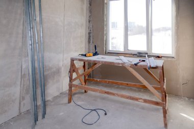 Büyük bir boş odada pencerede ahşap iskele standı, yeniden