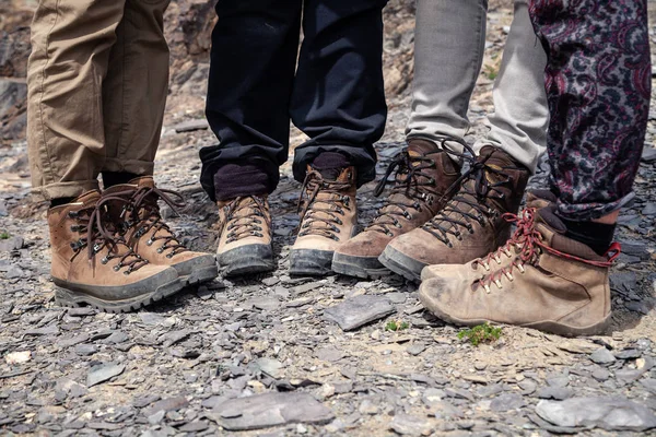 Company four tourists only legs together in brown trekking hikin