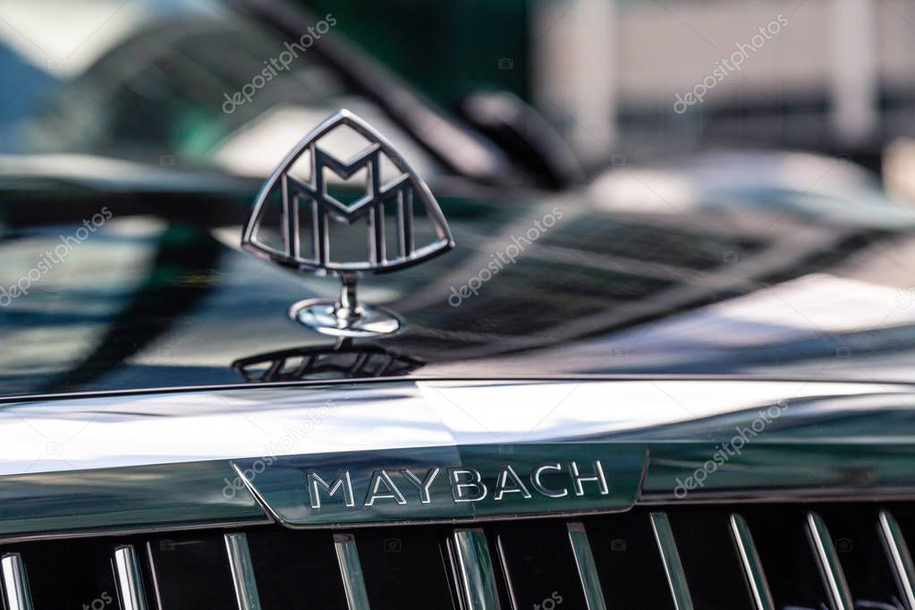 Russia Moscow 2019-06-17 Closeup emblem logo on front of brand Mercedes Maybach S500 dark blue car, sky and city reflection on car bonnet
