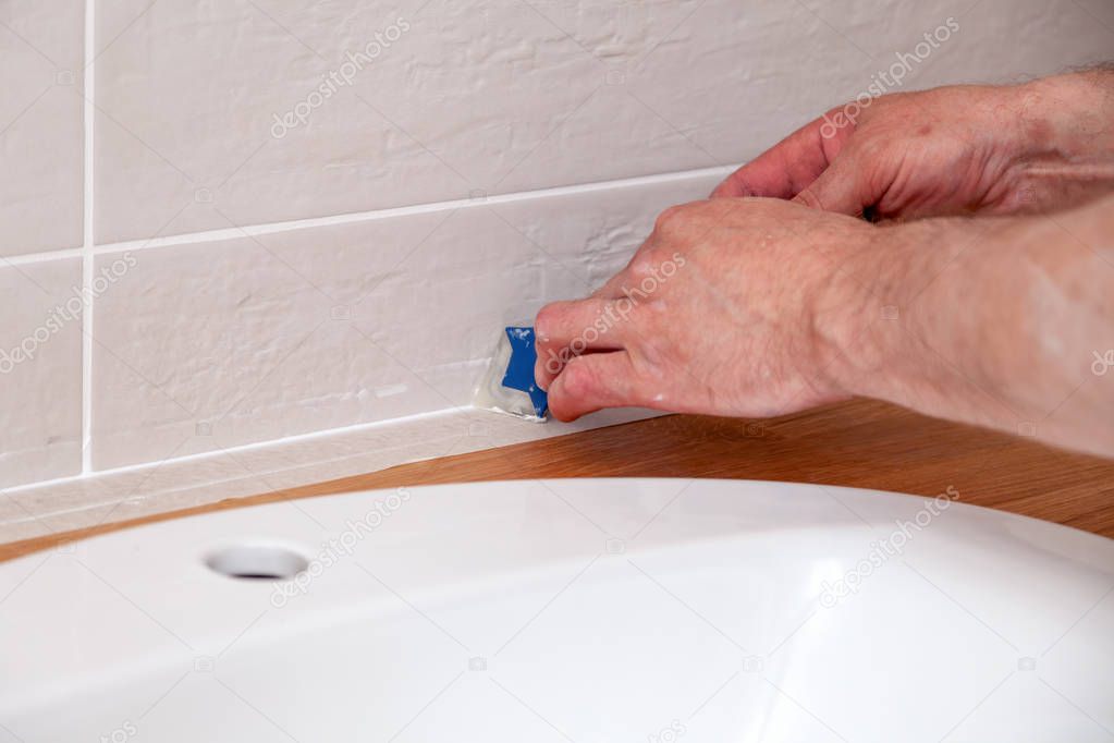 Closeup hands of professional plumber worker applying white seal