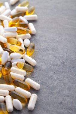 Tabletler, haplar, kapsüller, beyaz şişeden dökülen uyuşturucular.