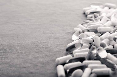 Tabletler, haplar, kapsüller, beyaz şişeden dökülen uyuşturucular.