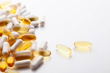 Tabletler, haplar, kapsüller, beyaz şişeden dökülen uyuşturucular.