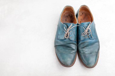 Bir çift eski deri mavi bağcıklı atılmış bot.