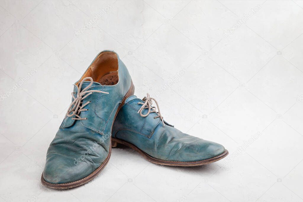 Pair of old leather blue discarded boots with laces