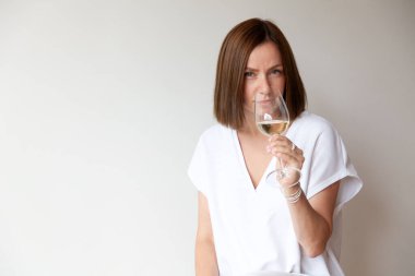 Kafkasyalı esmer kız şarap garsonu elinde beyaz şarap bardağıyla