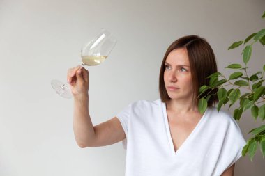 Kafkasyalı esmer kız şarap garsonu elinde beyaz şarap bardağıyla