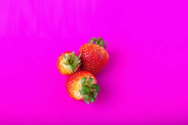 Taze kırmızı çilek, pembe arka planda çikolata parçaları, yakın plan.