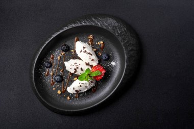 Oval tabakta tatlı, vanilyalı dondurma, yabanmersini, çilek, karamel sosu.