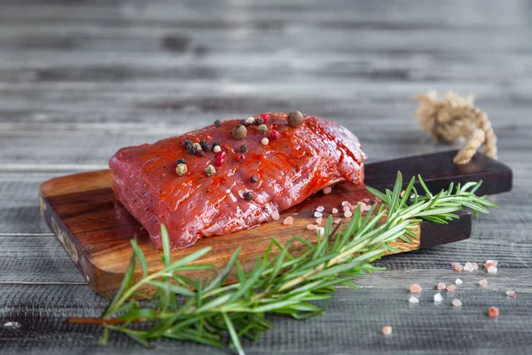 Carne de vaca inteira bife de lombo cru, alecrim, pimenta, sal marinho em tábua de madeira — Fotografia de Stock