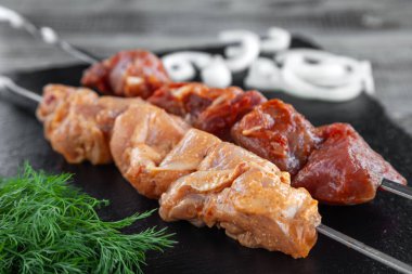 İki şiş kebap, taze çiğ et parçaları.