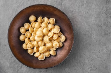 Hamurdan yapılmış et ya da sebze dolması ve kaynatılmış pelmeni adı verilen hamur köftesi tabağı.